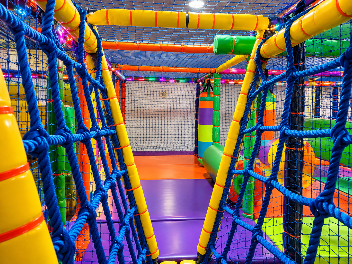 Puente pasarela y circuito de redes acolchado en parque infantil